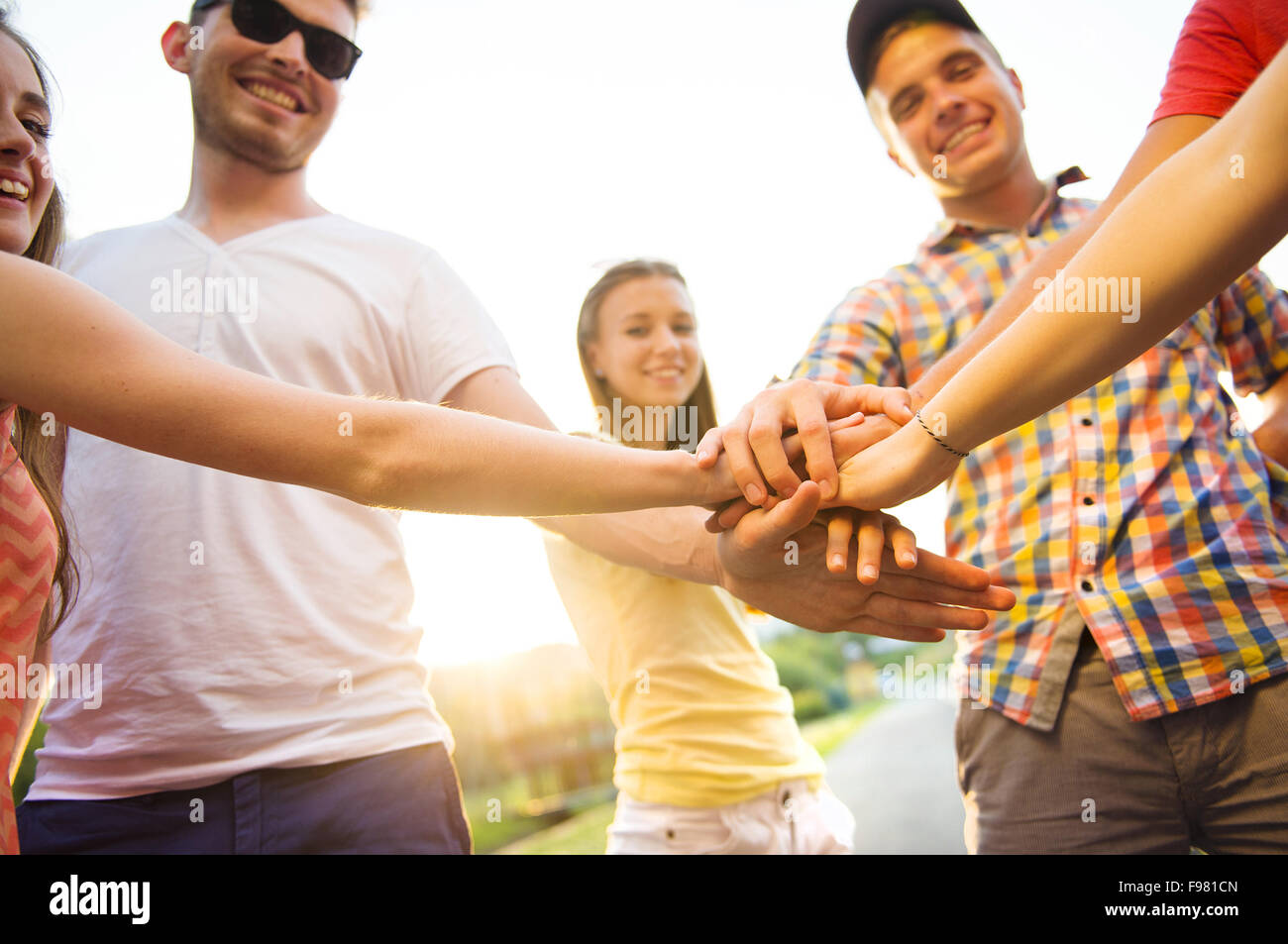 Group of young people with hands in stack Stock Photo - Alamy