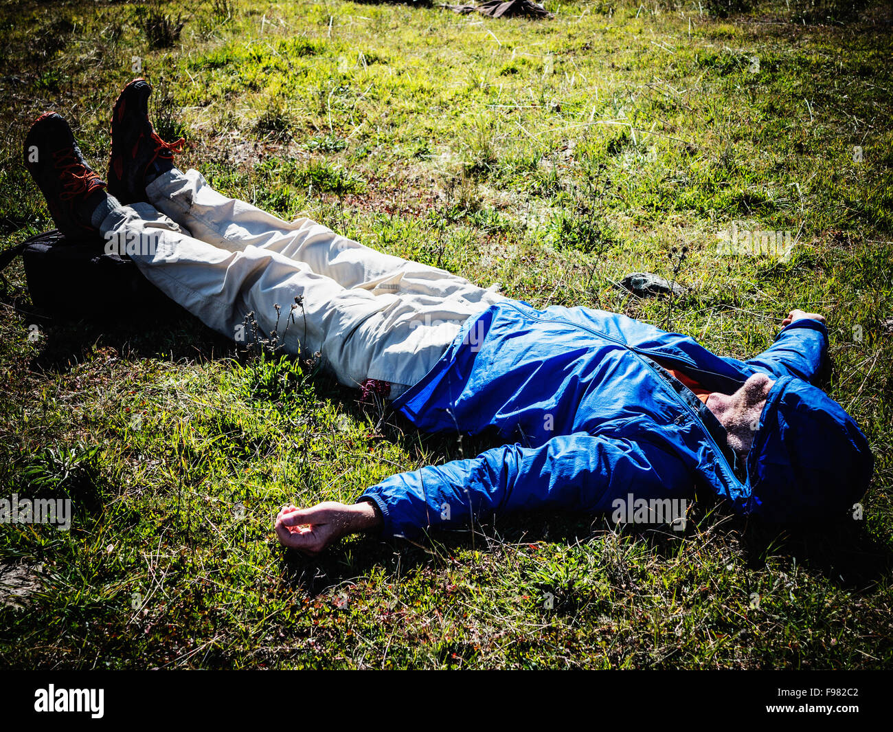 A man laying down on the ground after an exhausing hike Stock Photo - Alamy