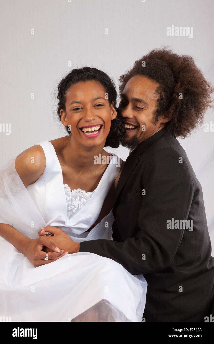 Romantic Black couple, she in a wedding dress and touching Stock Photo