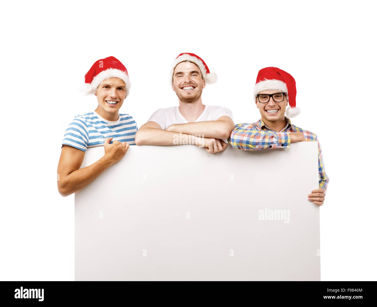 Three young men in santa hats with copy space, isolated on white background Stock Photo