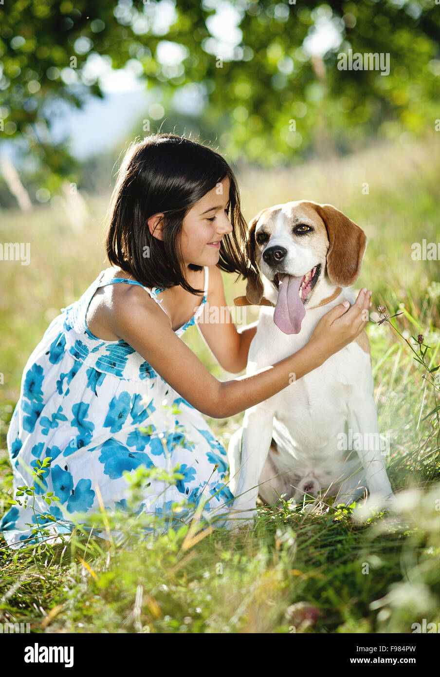 Cute little girl is playing with her dog in the green park Stock Photo ...