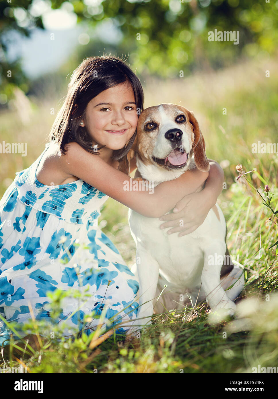 Cute little girl is playing with her dog in the green park Stock Photo ...