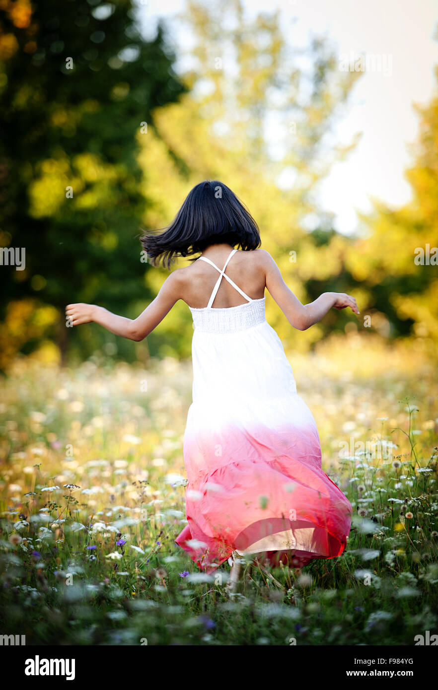 Happy little girl is playing in the green sunny park Stock Photo - Alamy