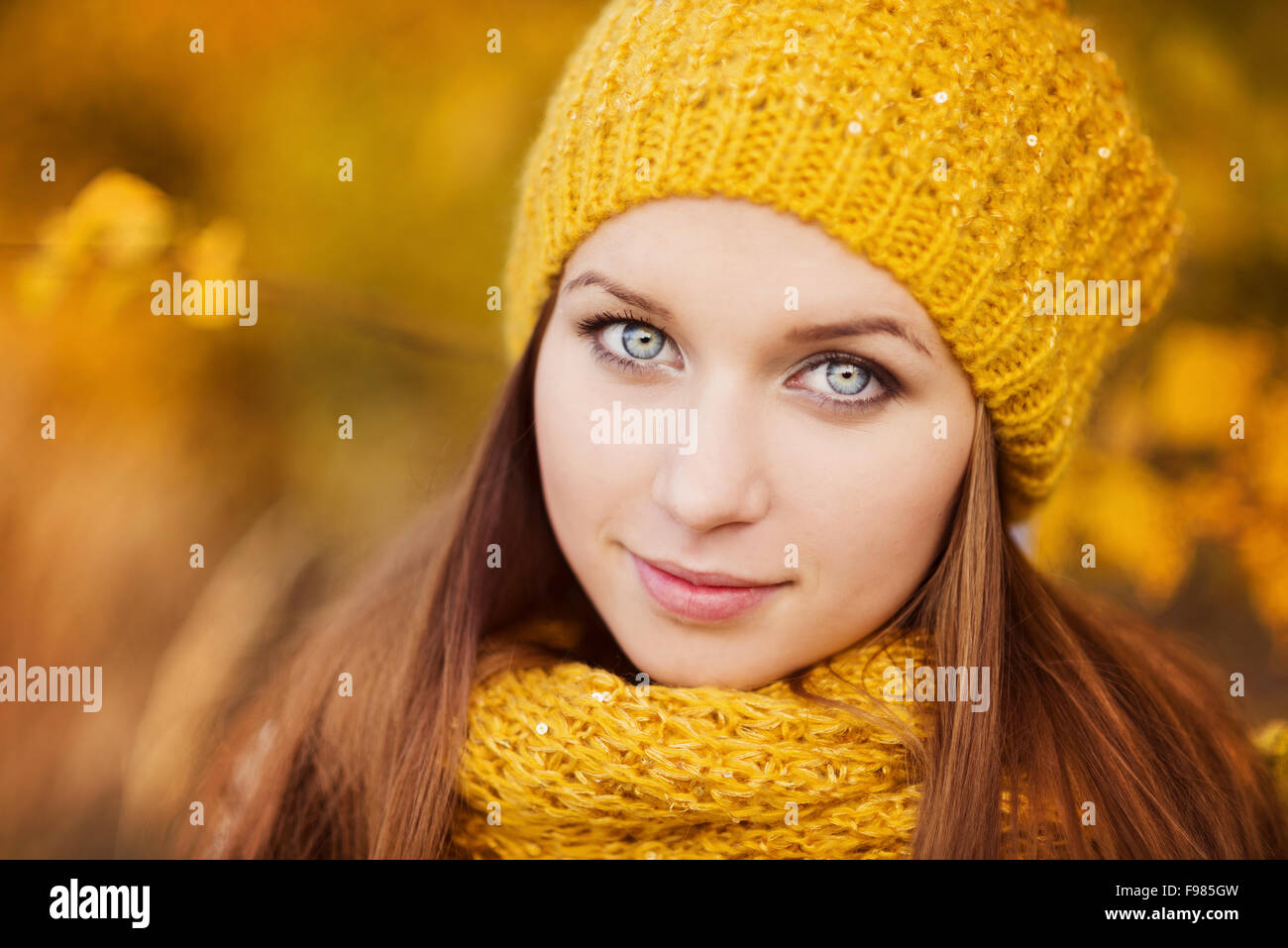 Portrait of beautiful girl with scarf and hat in yellow autumn nature ...
