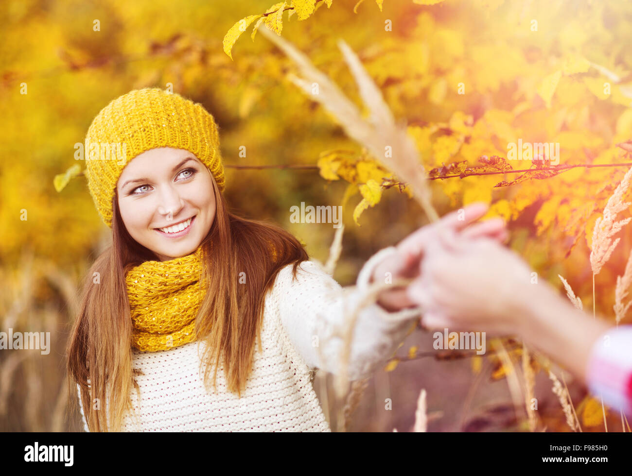 Portrait of beautiful girl with scarf and hat in yellow autumn nature ...