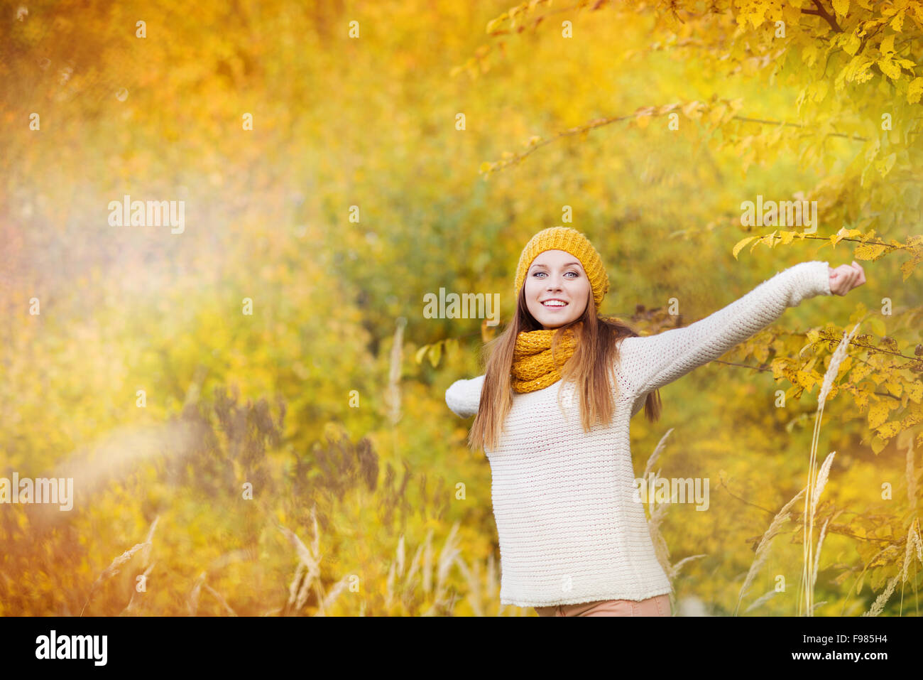 Portrait of beautiful girl with scarf and hat in yellow autumn nature ...