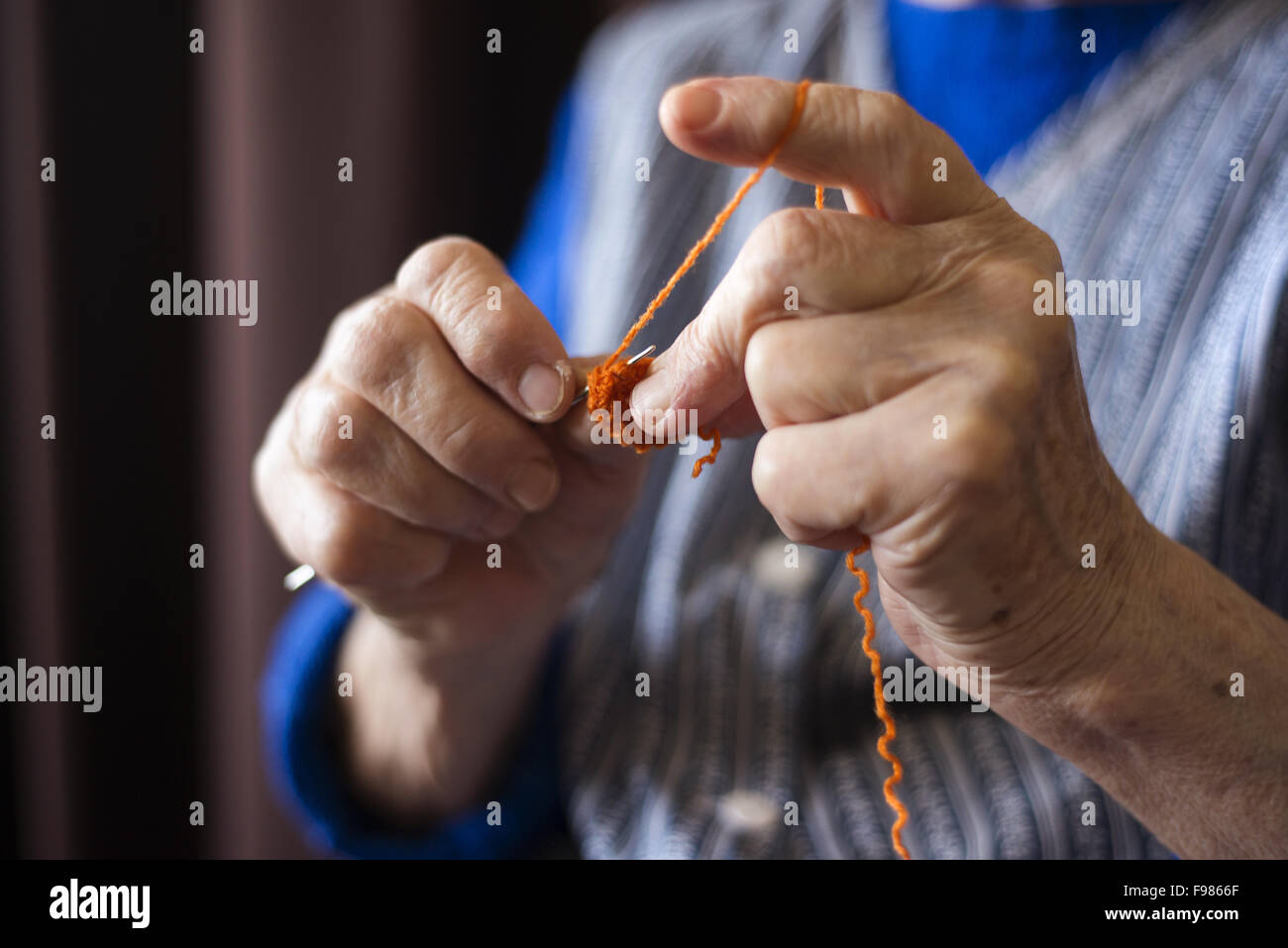 Hands of senior woman knitting with wool and knitting needles Stock Photo