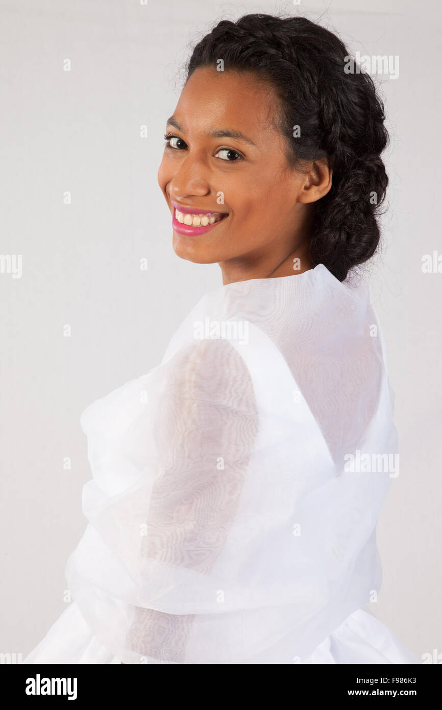 Pretty black woman in a white wedding type of dress, looking happy Stock Photo