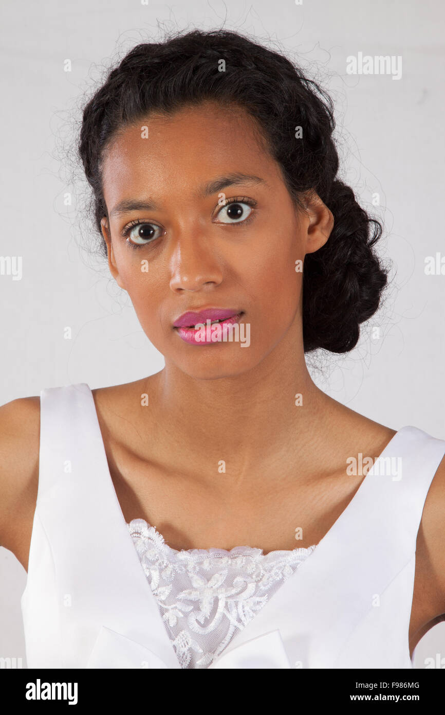 Pretty black woman in a white wedding type of dress, looking thoughtful Stock Photo