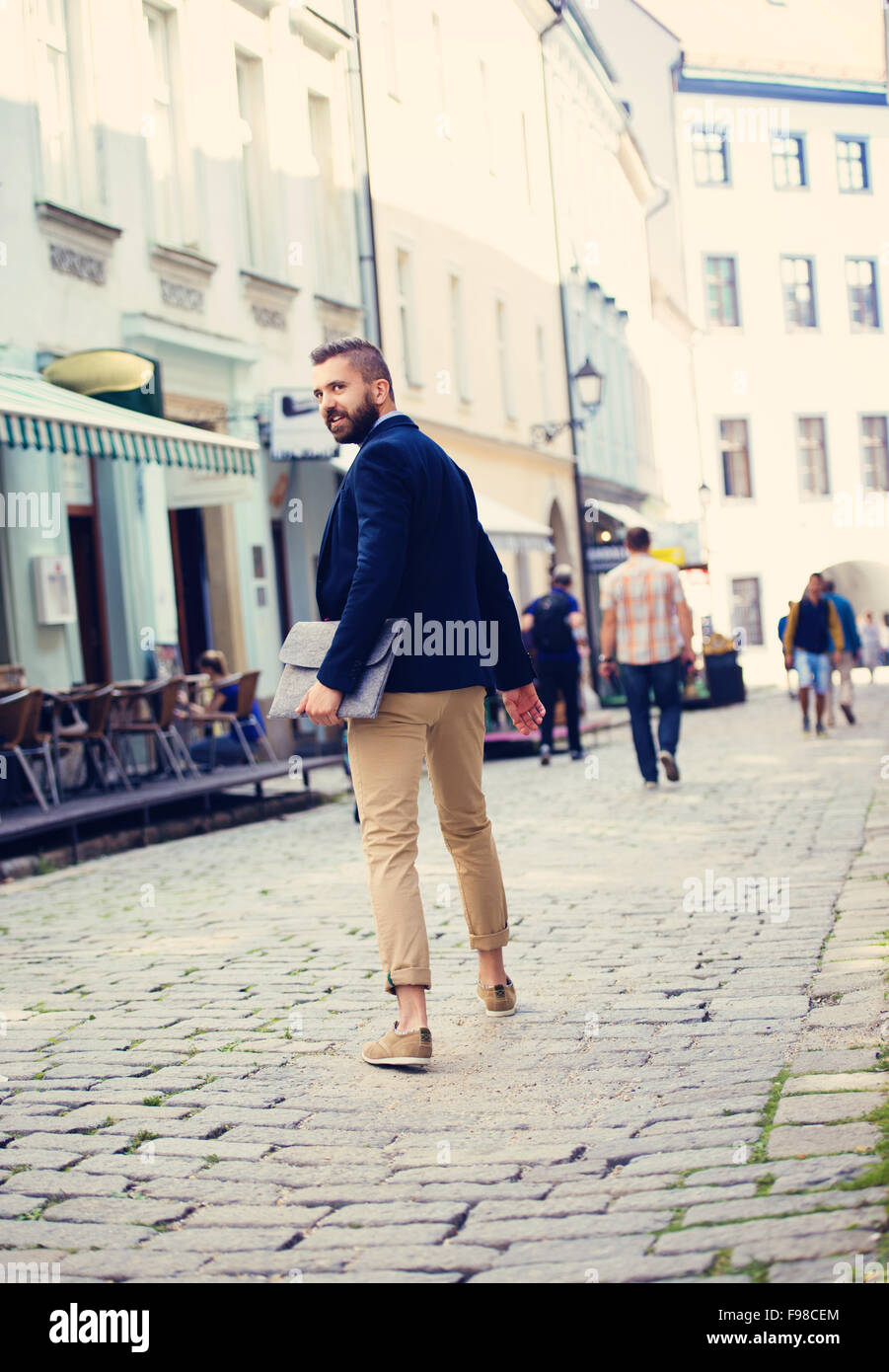 Handsome modern hipster businessman with bag hurrying to work Stock Photo
