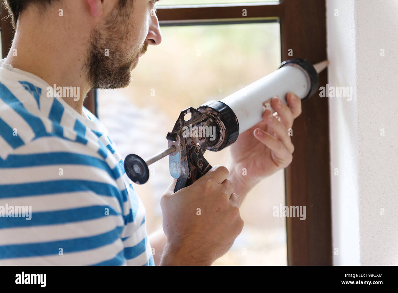 Man applying silicone sealant with caulking gun Stock Photo Alamy