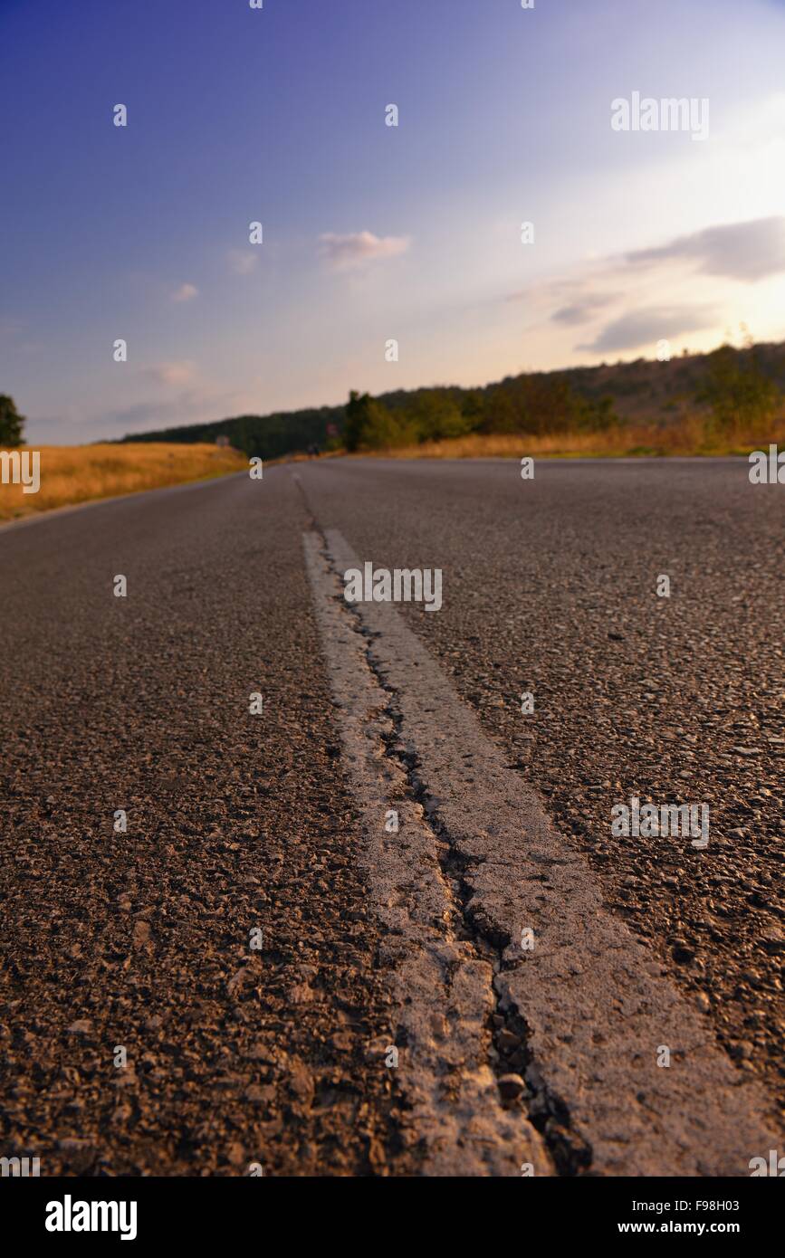 asphalt road through the green field and clouds on blue sky in summer ...