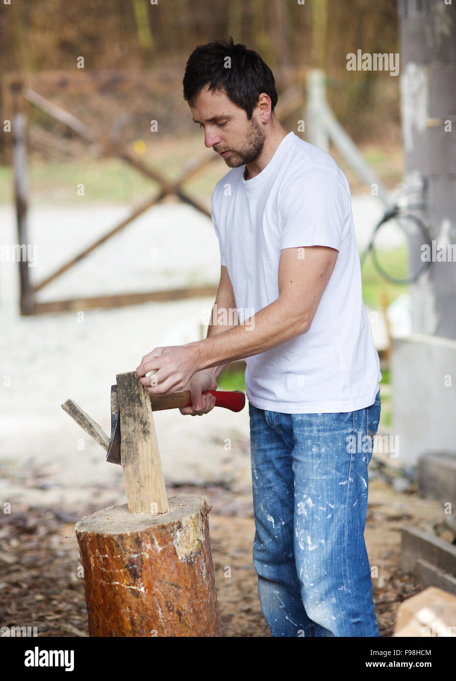 Young man chopping wood in his backyard Stock Photo Alamy