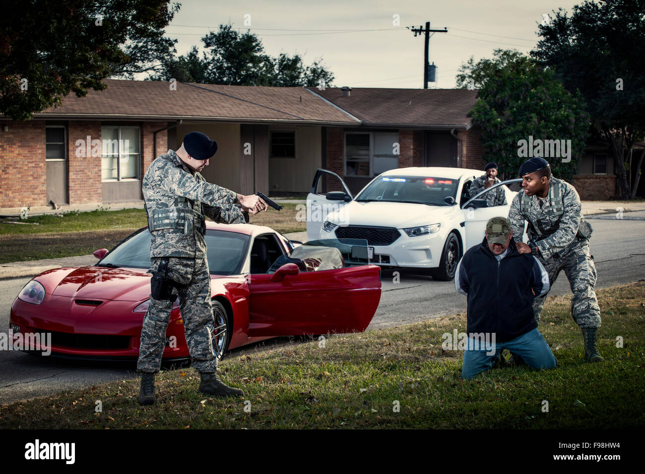 Air Force Security Forces members execute the apprehension of a resistant-armed driver during a traffic stop during training. Stock Photo