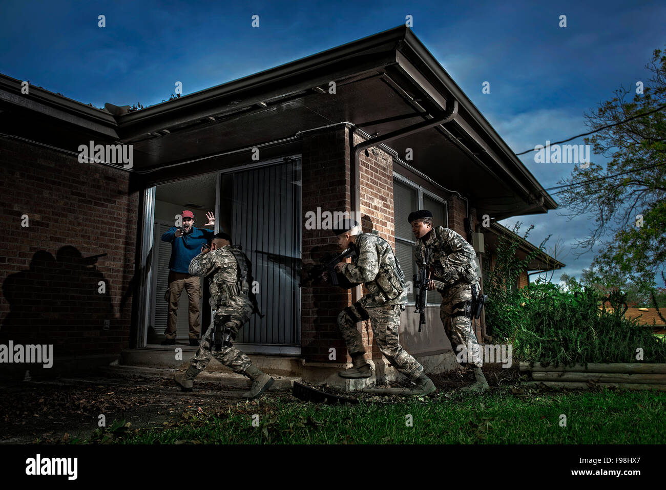 An Air Force Security Forces team prepare to take down an armed perpetrator inside a domestic home during a simulated hostage situation. Stock Photo