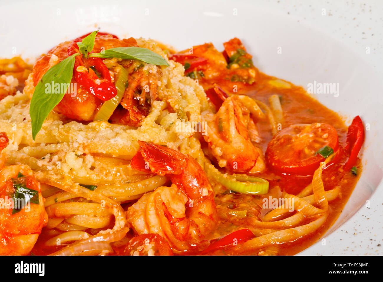 A plate of linguini with sauteed shrimp, tomato, chili and olive oil ...