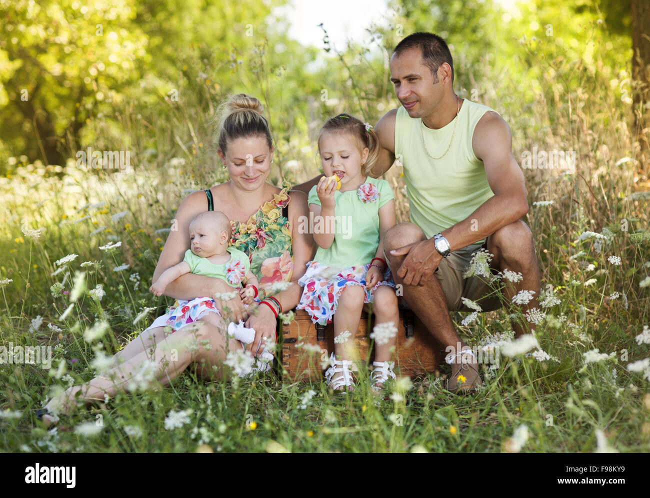 Happy young family spending time together in green nature. Stock Photo
