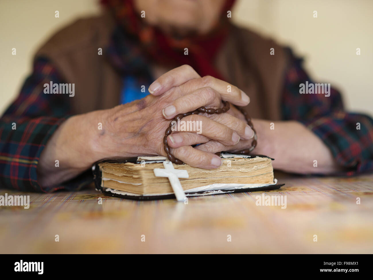 Detail of very old woman in head scarf praying Stock Photo