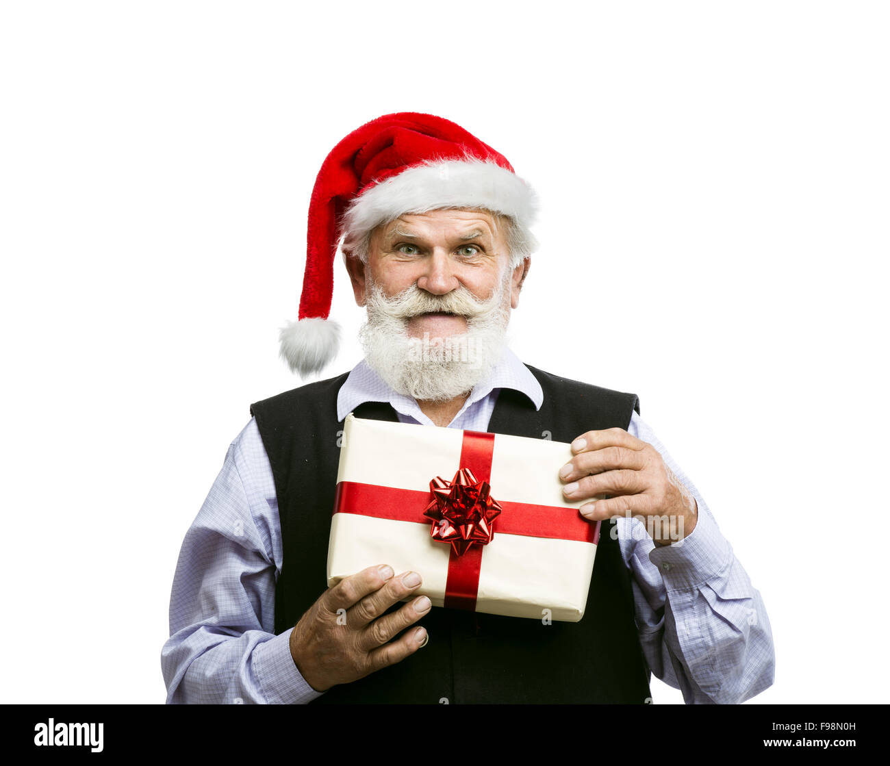 Old bearded man in santa hat holding Christmas gift isolated on white background Stock Photo