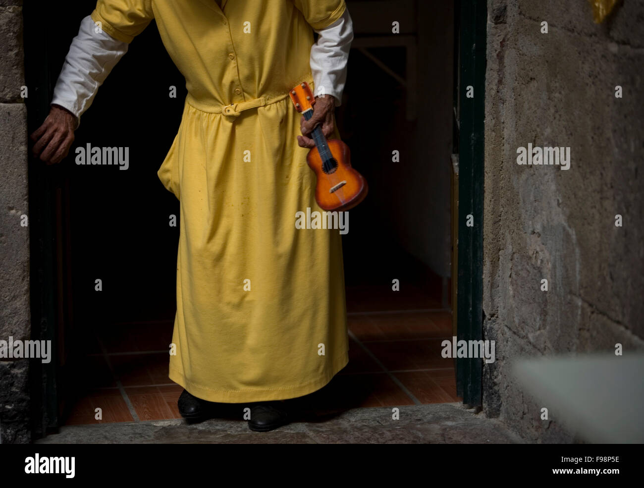 An elderly woman, walks with a toy guitar in Our Lady of Guadalupe Home for the Elderly, Mexico City Stock Photo