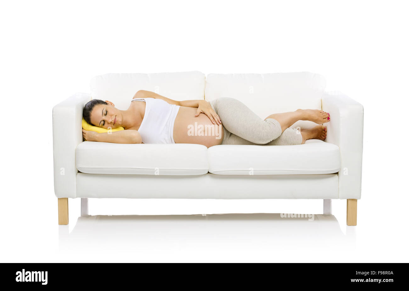 Studio portrait of tired pregnant woman lying down on sofa isolated on