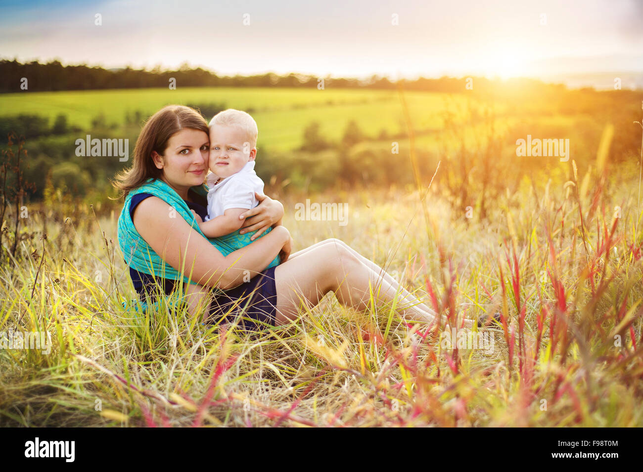 Happy mother holding her son in nature. Stock Photo