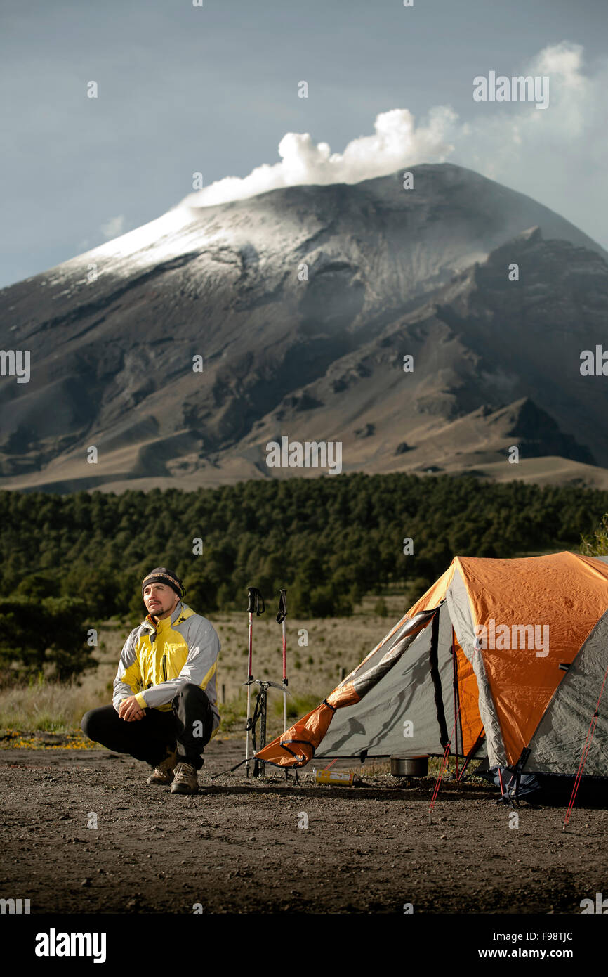 A man and his tent at Paso the Cortez, with the Popocatepetl volcano in the back. Stock Photo
