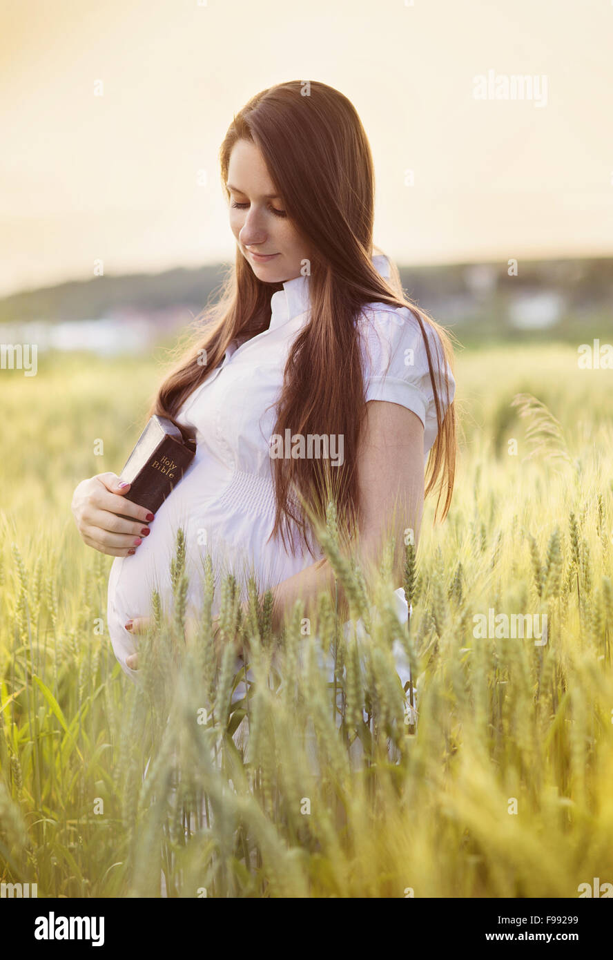 Outdoor portrait of young pregnant woman praying in the field Stock ...