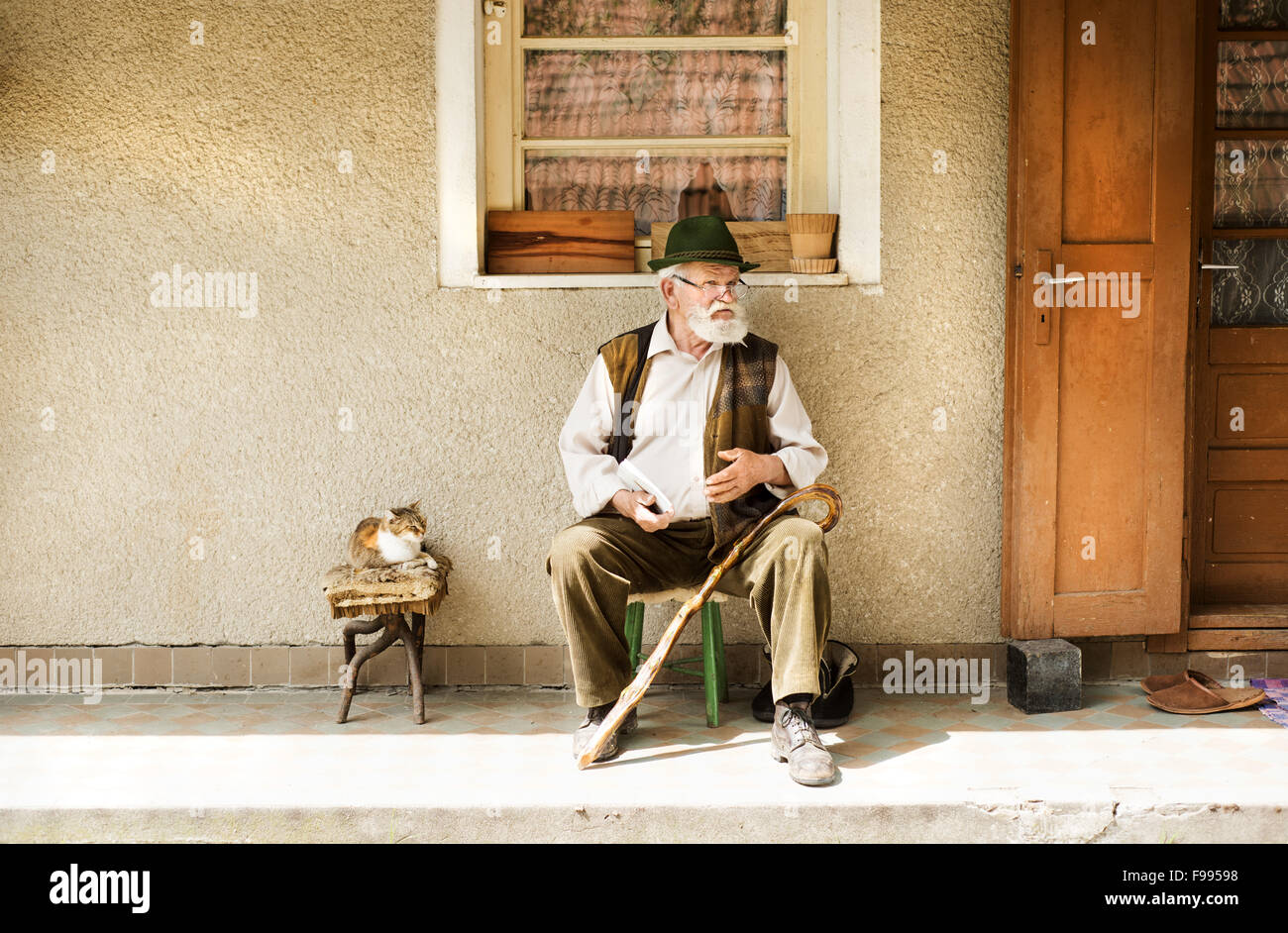 Old man reading the newspaper in front of his house Stock Photo