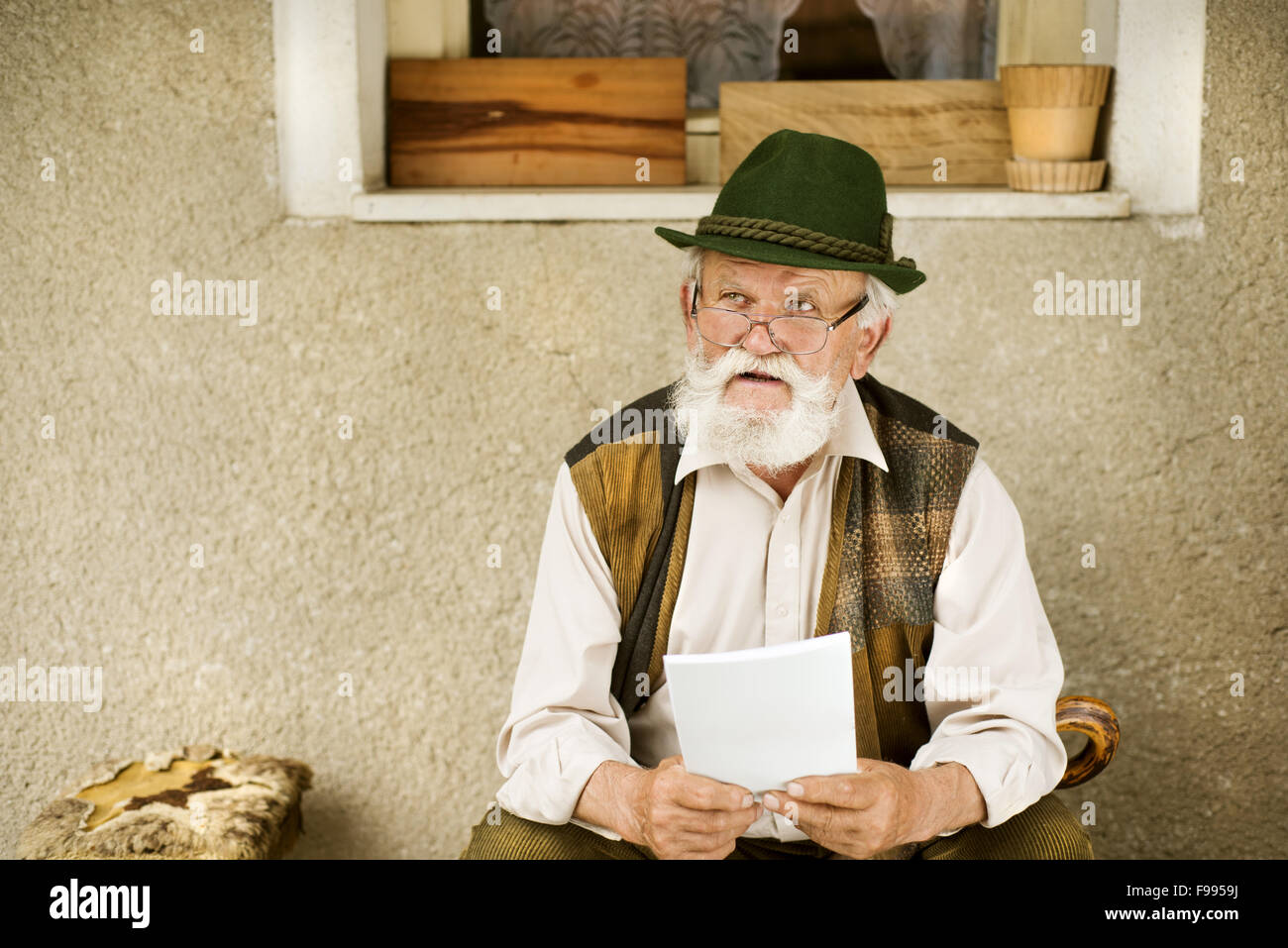 Old man reading the newspaper in front of his house Stock Photo