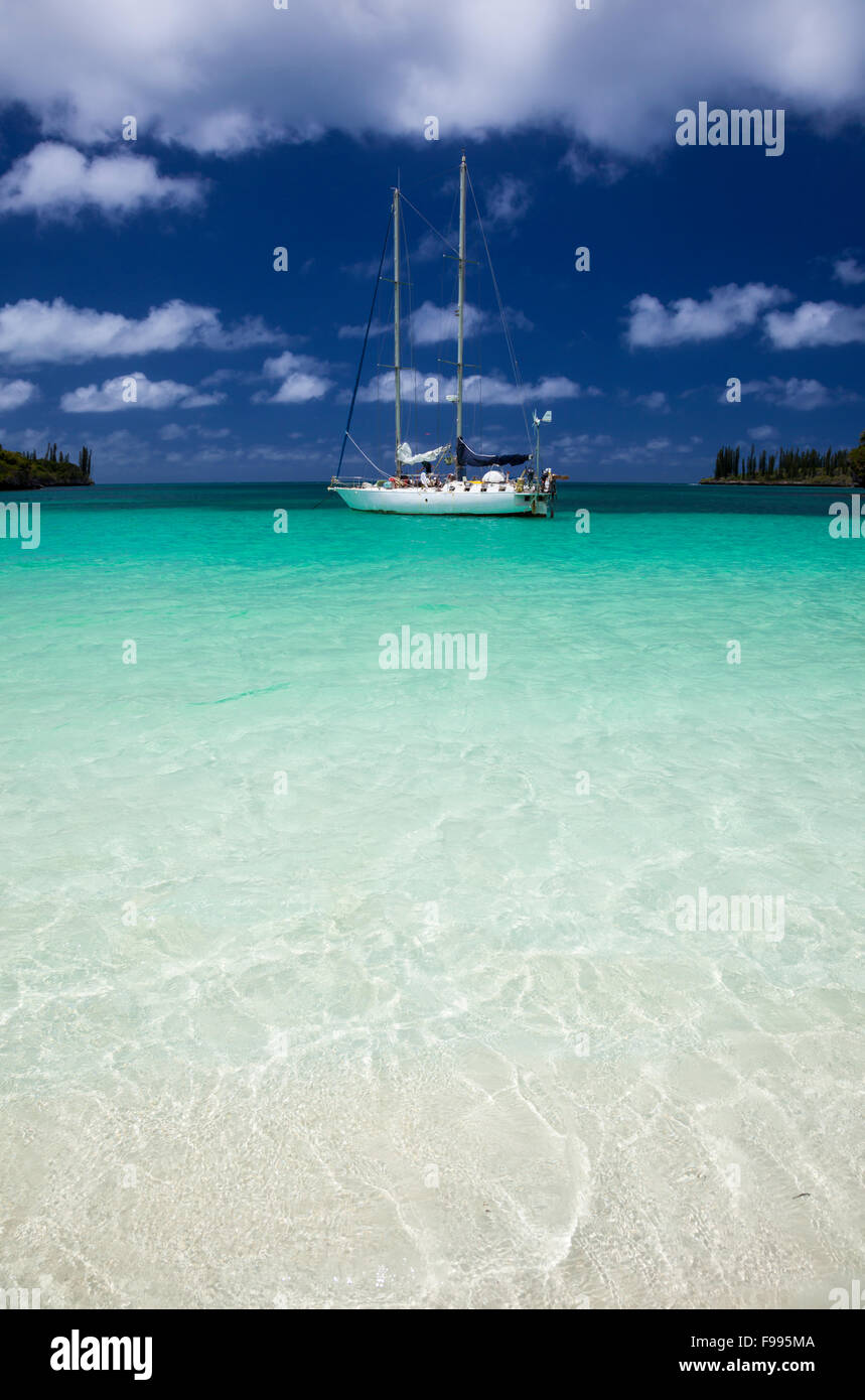 The Isle of Pines' Kanumera Bay provides an idyllic, turquoise anchorage for visiting yachts. Stock Photo