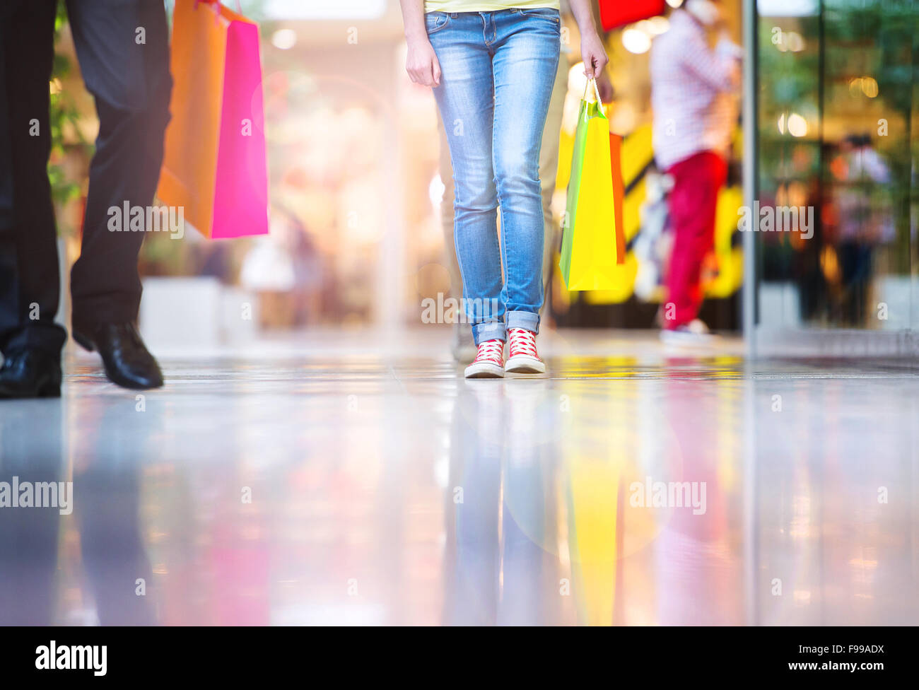 Detail of legs of young couple with bags in shopping mall Stock Photo