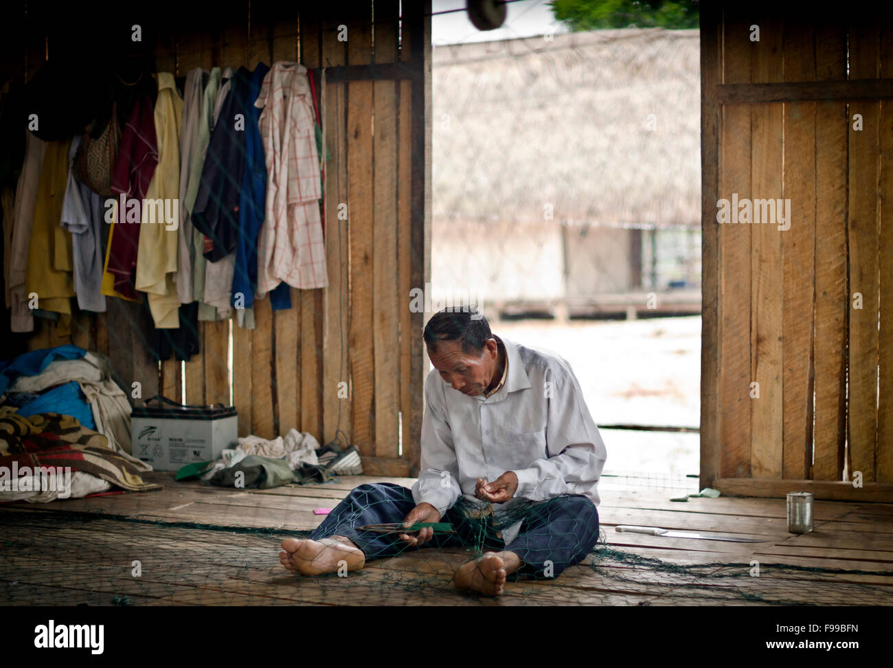 Man repairing his fishing net, Charashmana, Shipibo tribe remote village on a Pisqui river ,Amazon forest Peru Stock Photo