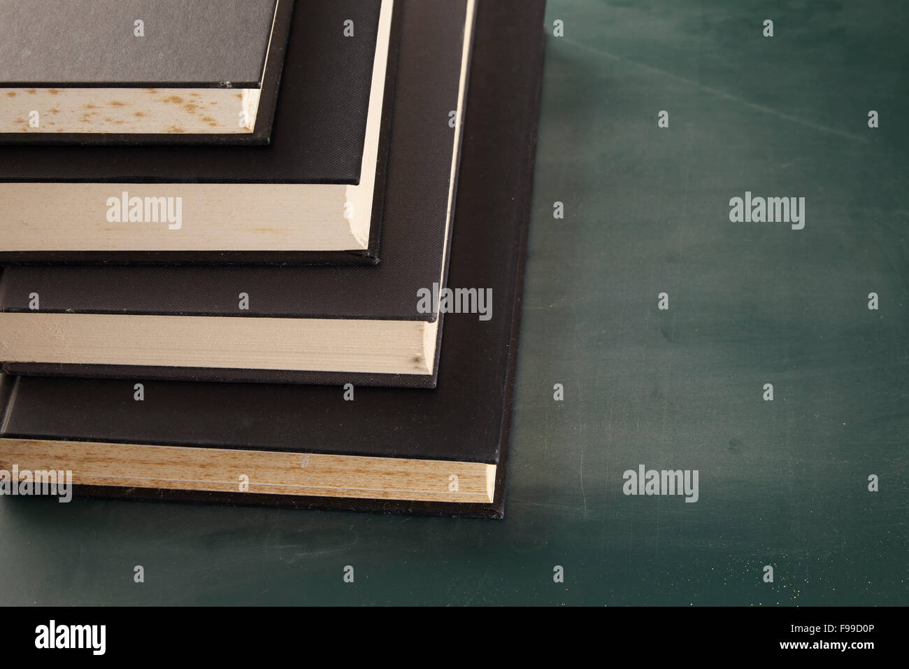 stack of books on the blackboad Stock Photo - Alamy