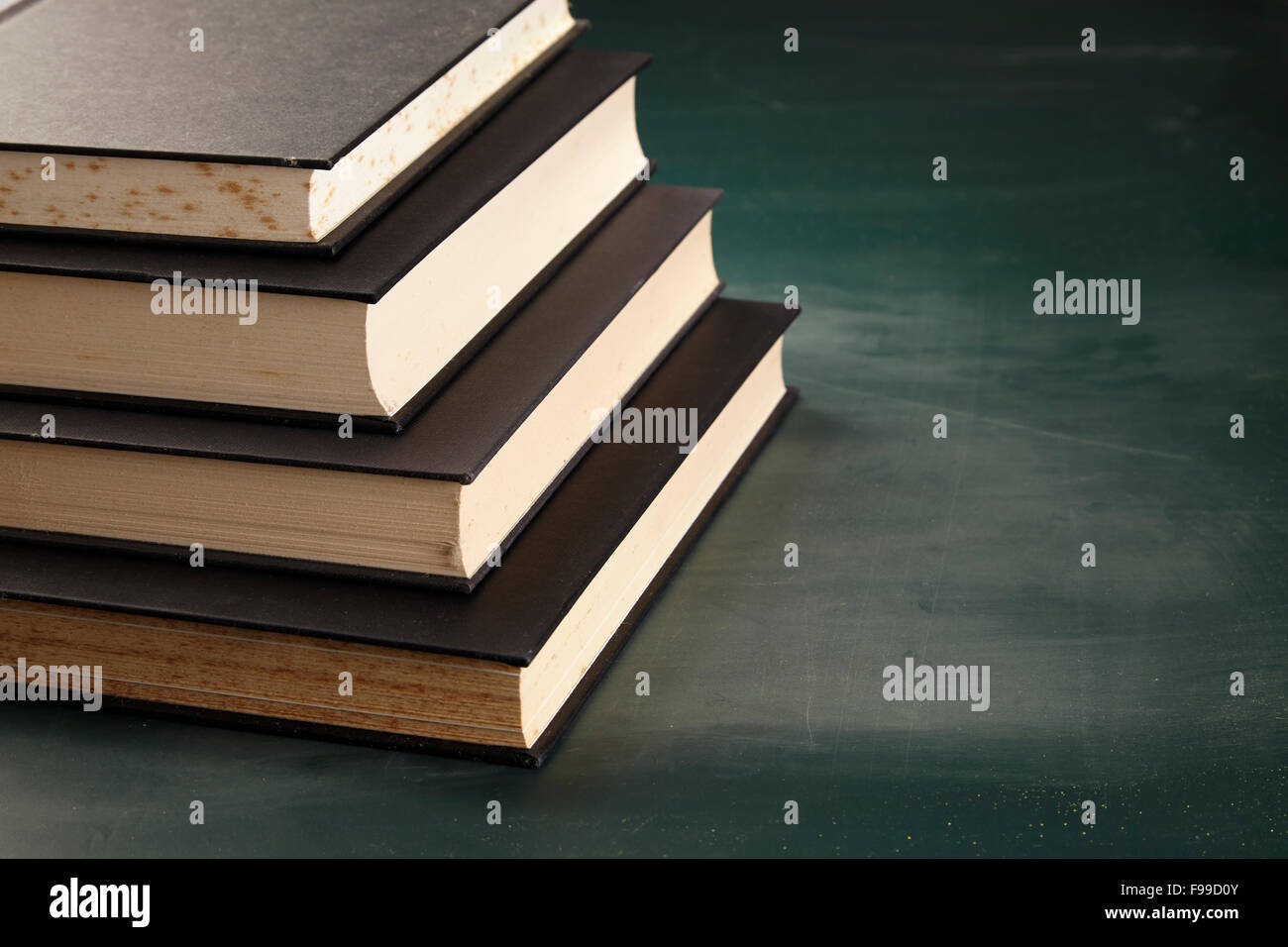 stack of books on the blackboad Stock Photo - Alamy