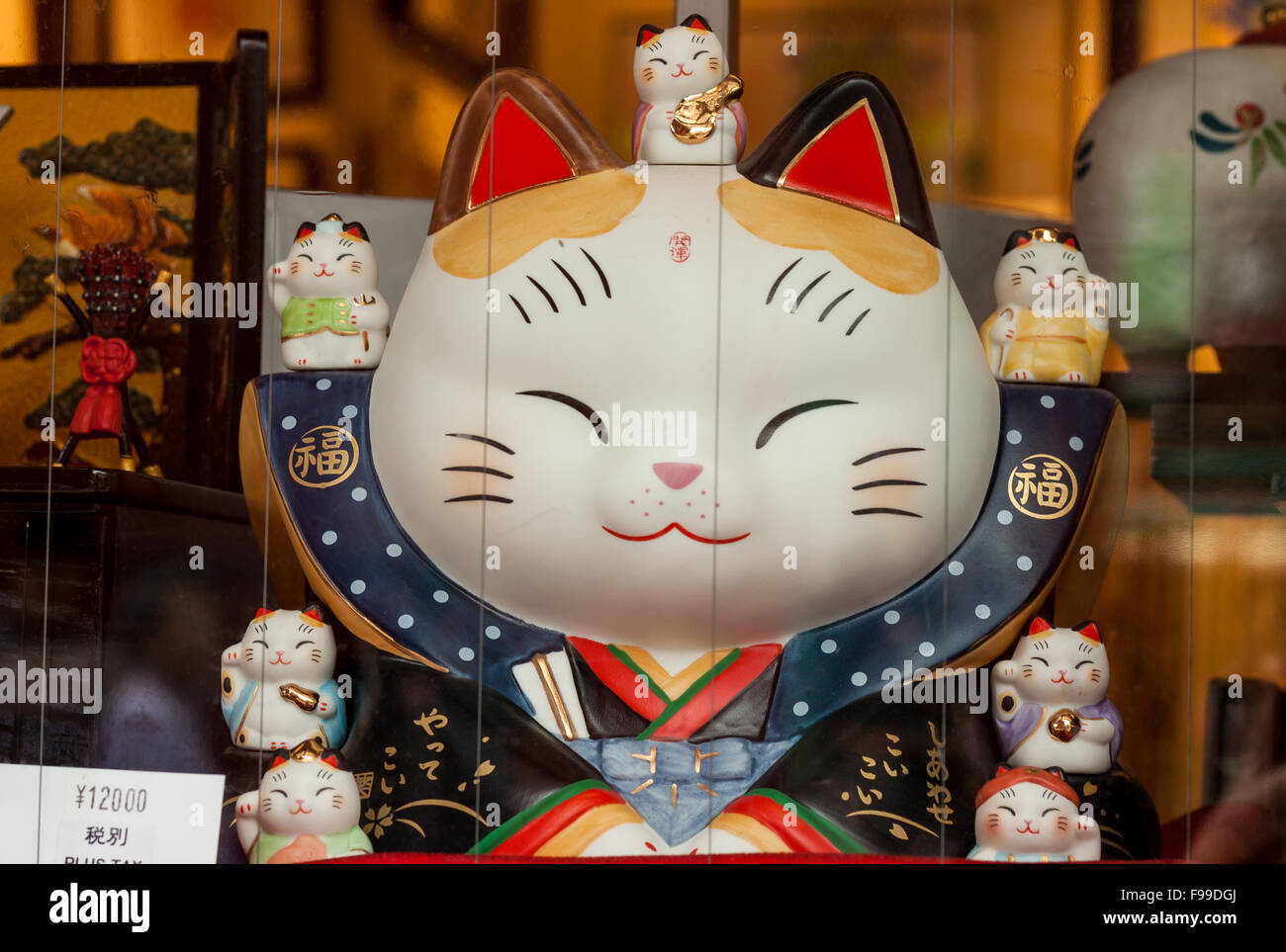 TOKYO, JAPAN - JUNE 27, 2015: Maneki-neko, japanese lucky charm cat figurine, on display in a shop in Asakusa district, Tokyo. Stock Photo