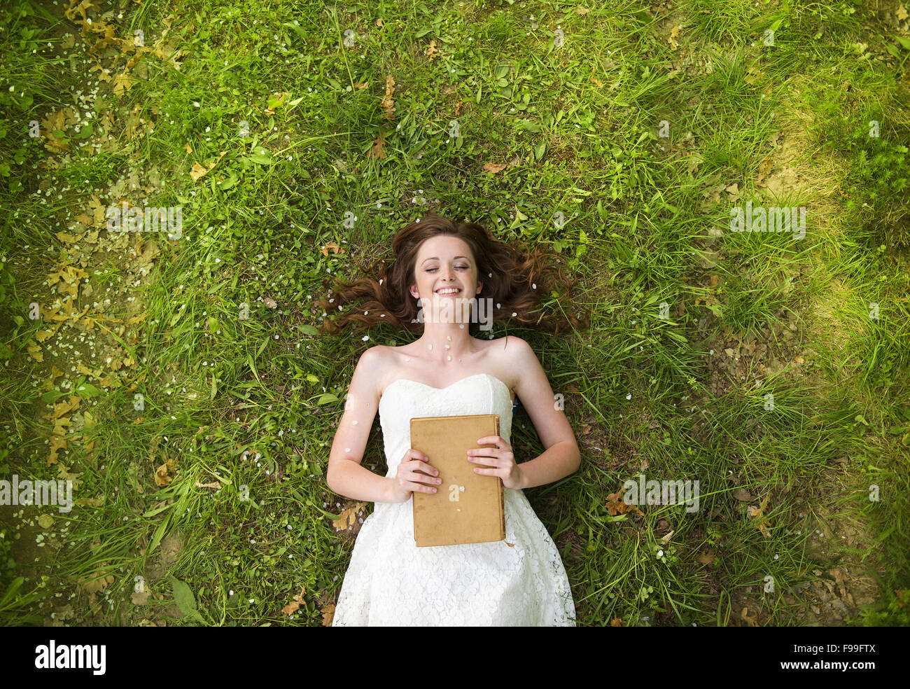 Young girl lying on the grass in green park Stock Photo - Alamy