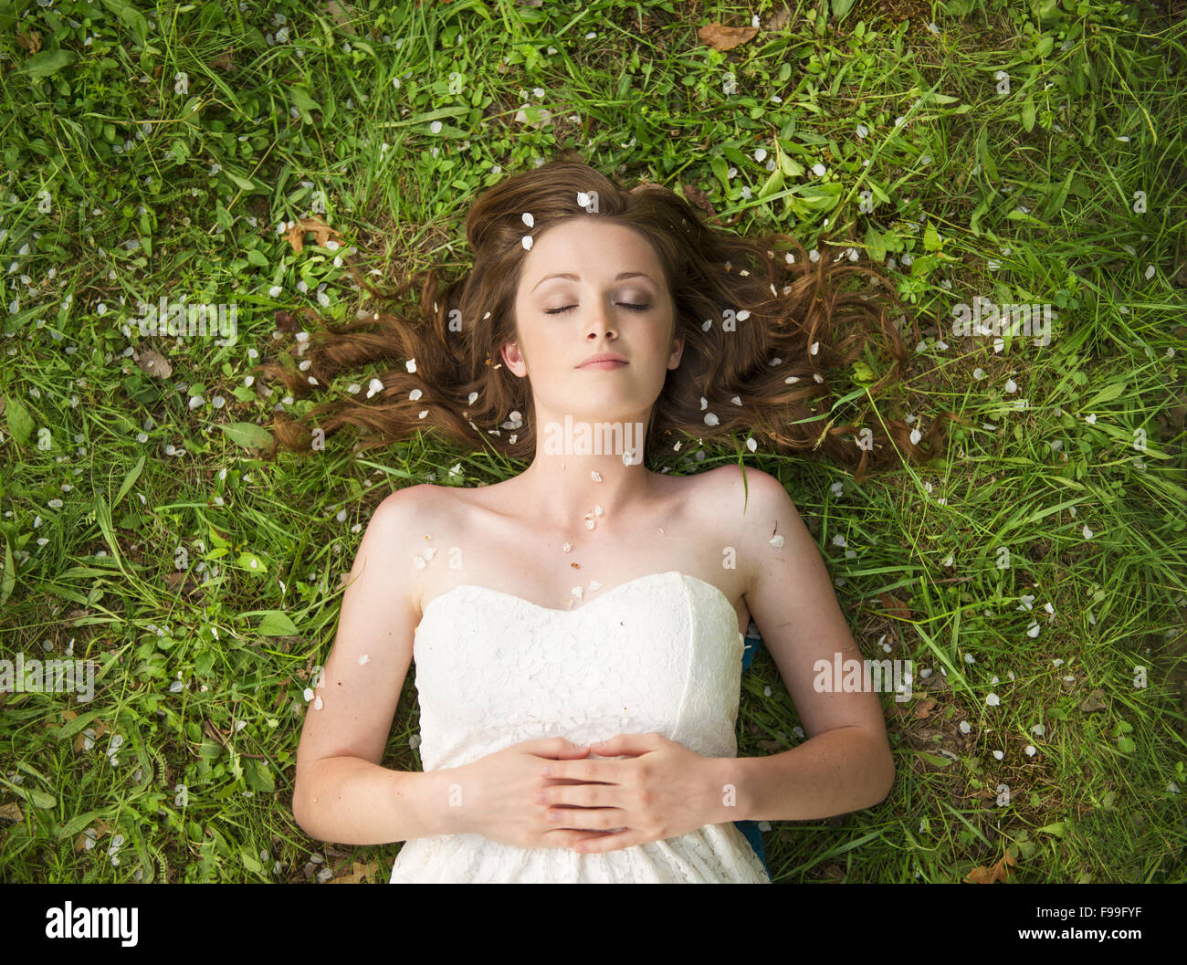 Young girl lying on the grass in green park Stock Photo - Alamy