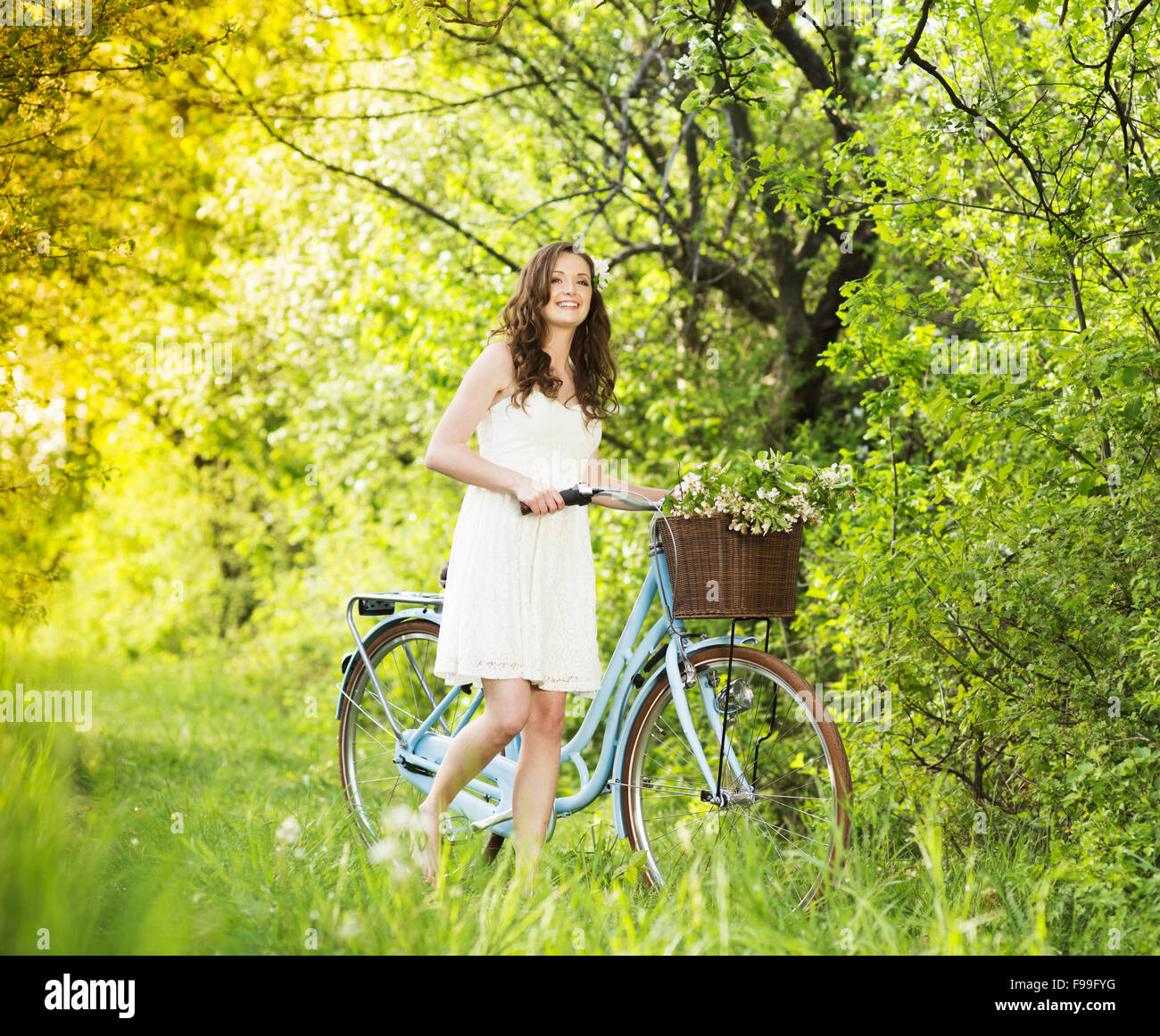 Pretty young woman with retro bike in green park Stock Photo