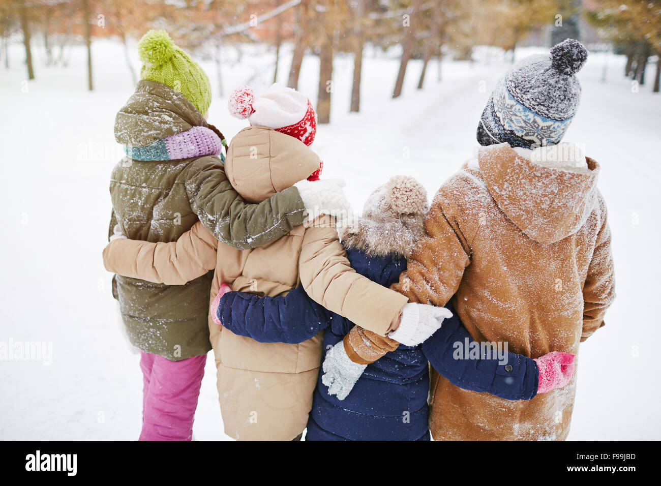 Little friends standing in embrace in winter forest Stock Photo