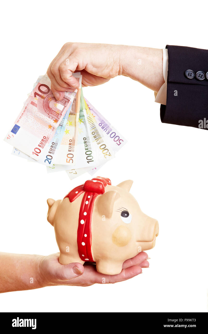 Hands putting Euro money in a piggy bank Stock Photo