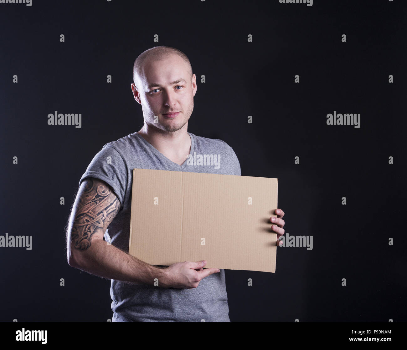 Handsome young man with tattoo, isolated on black Stock Photo - Alamy