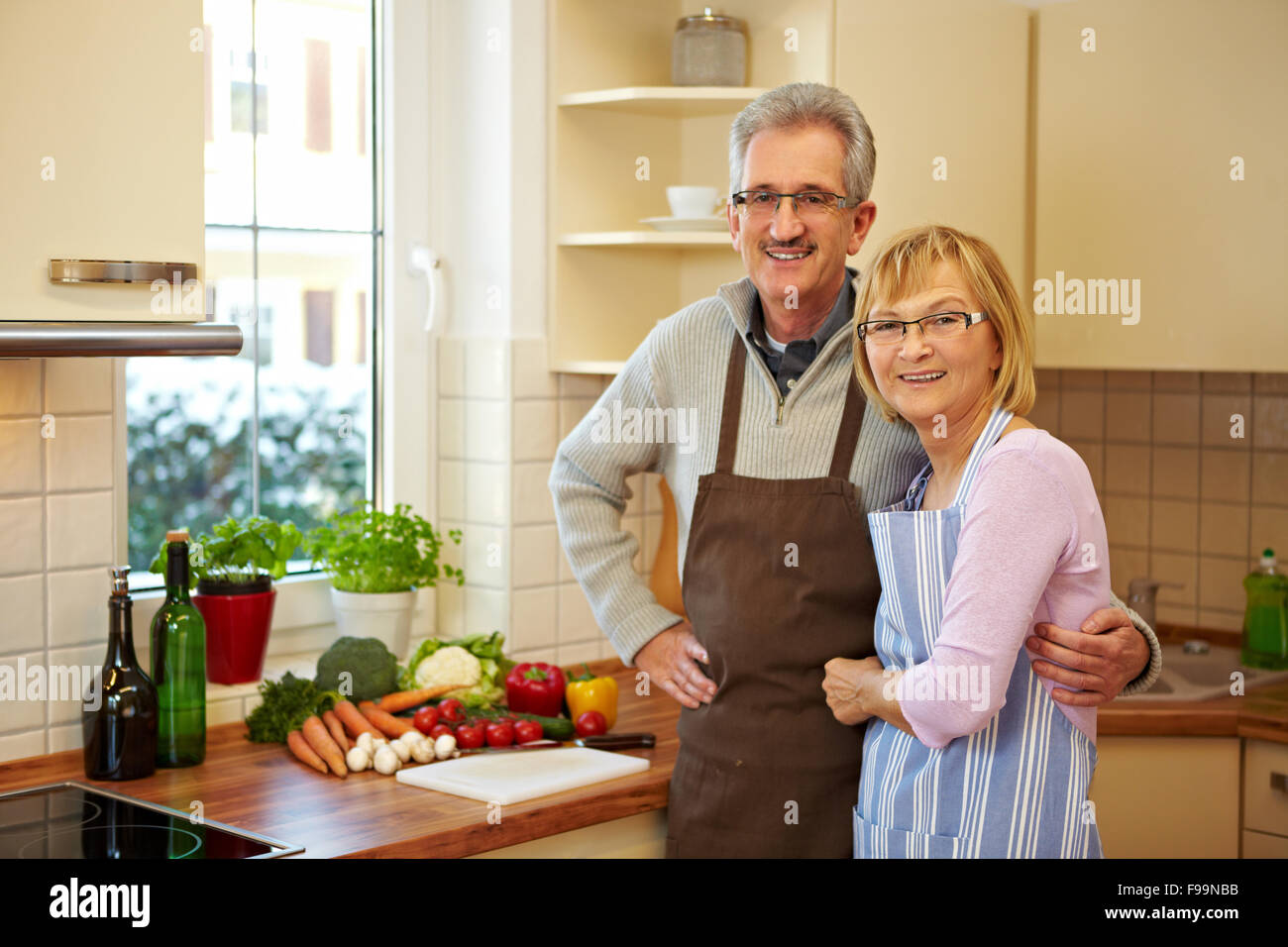 Happy elderly couple standing smiling in a new kitchen Stock Photo - Alamy