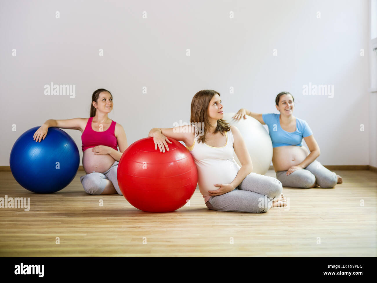 Young pregnant women doing relaxation exercise using a fitness ball Stock Photo