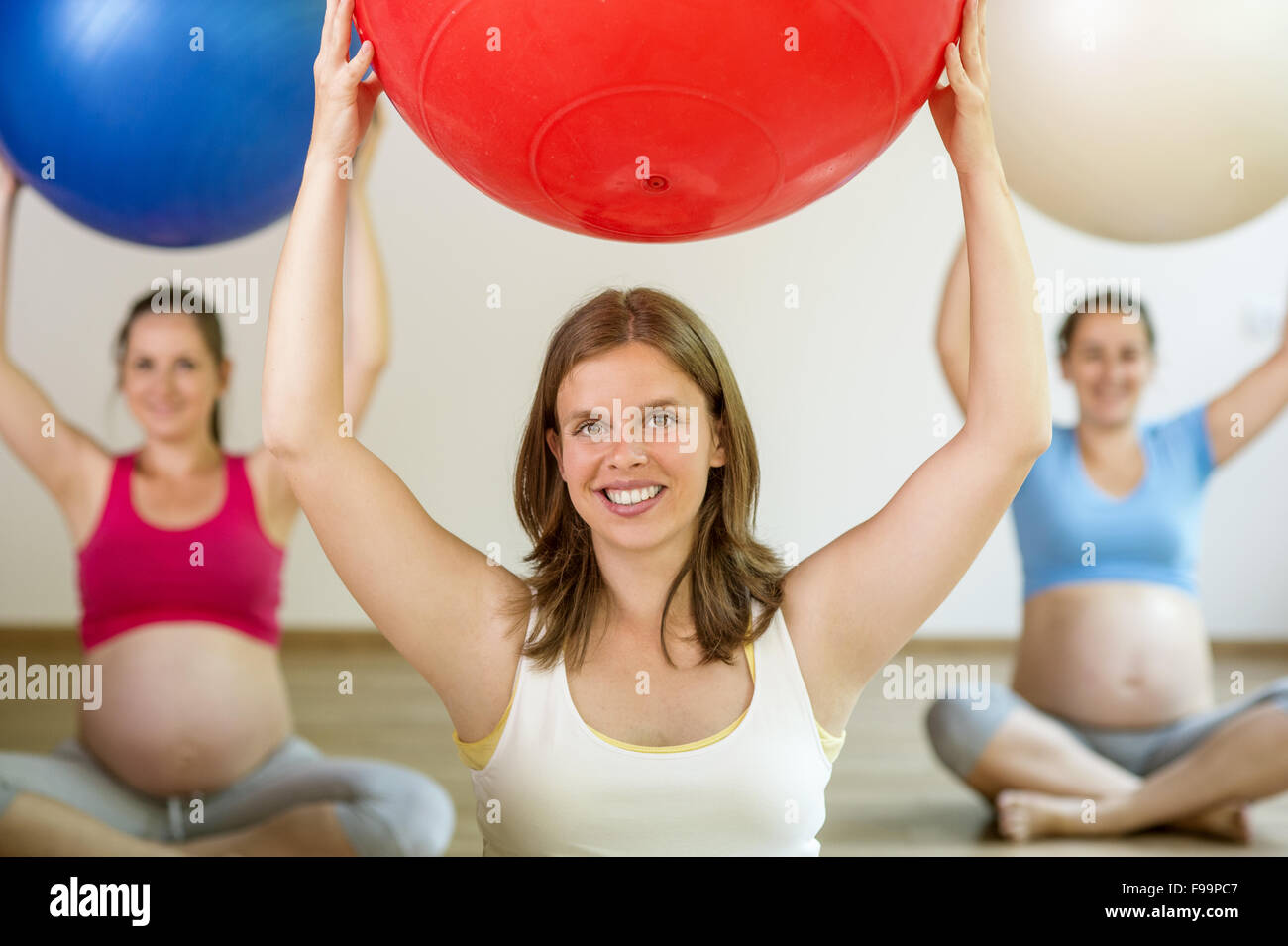 Young pregnant women doing relaxation exercise using a fitness ball Stock Photo
