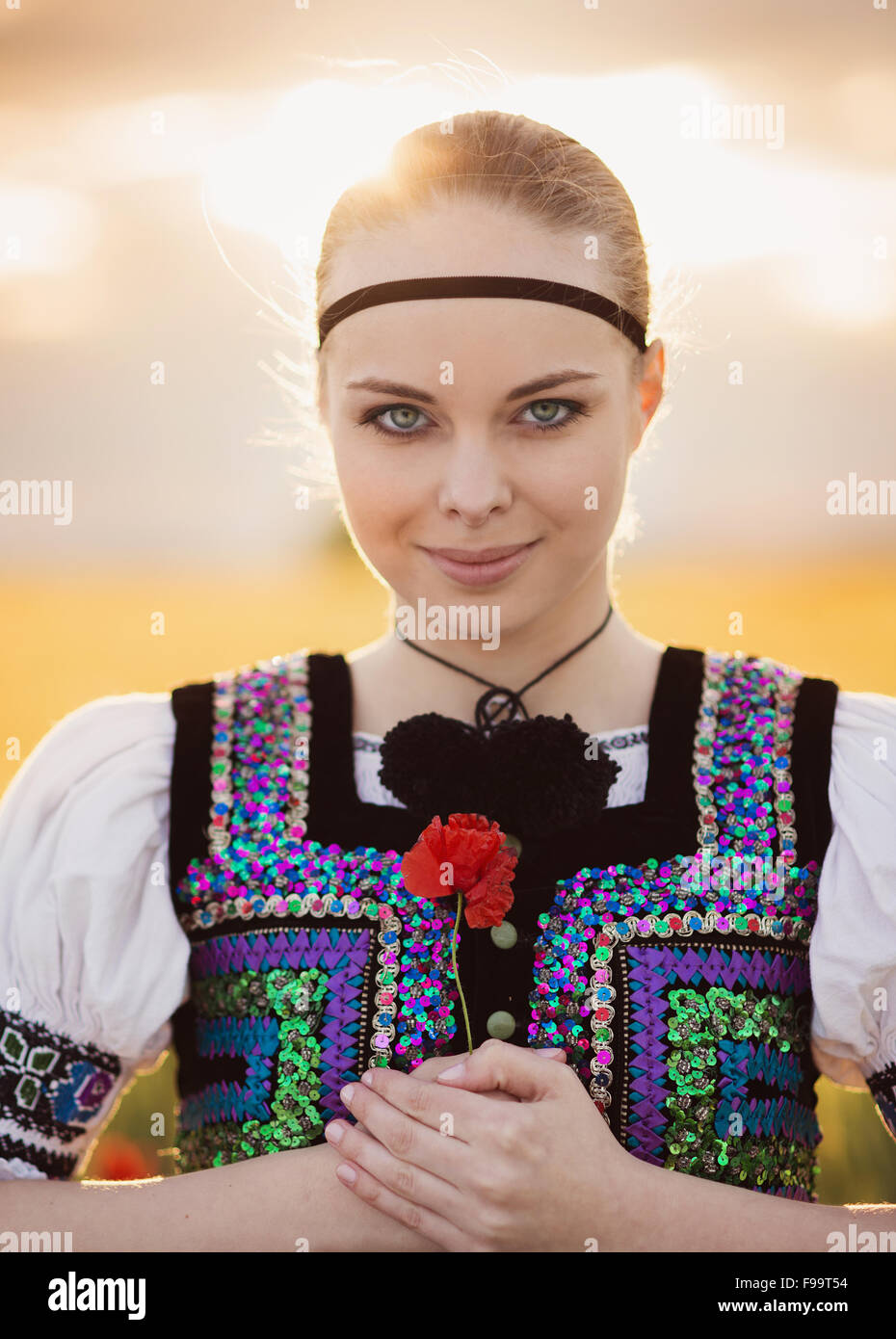 Beautiful woman in the field. She is wearing traditional Eastern Europe folk costumes. Stock Photo