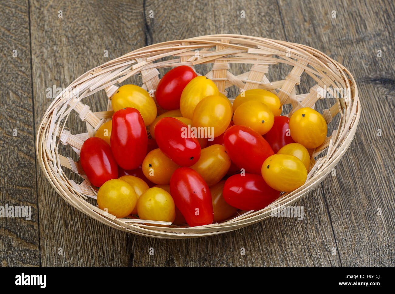 Yellow and red cherry tomatoes mix on the basket Stock Photo - Alamy