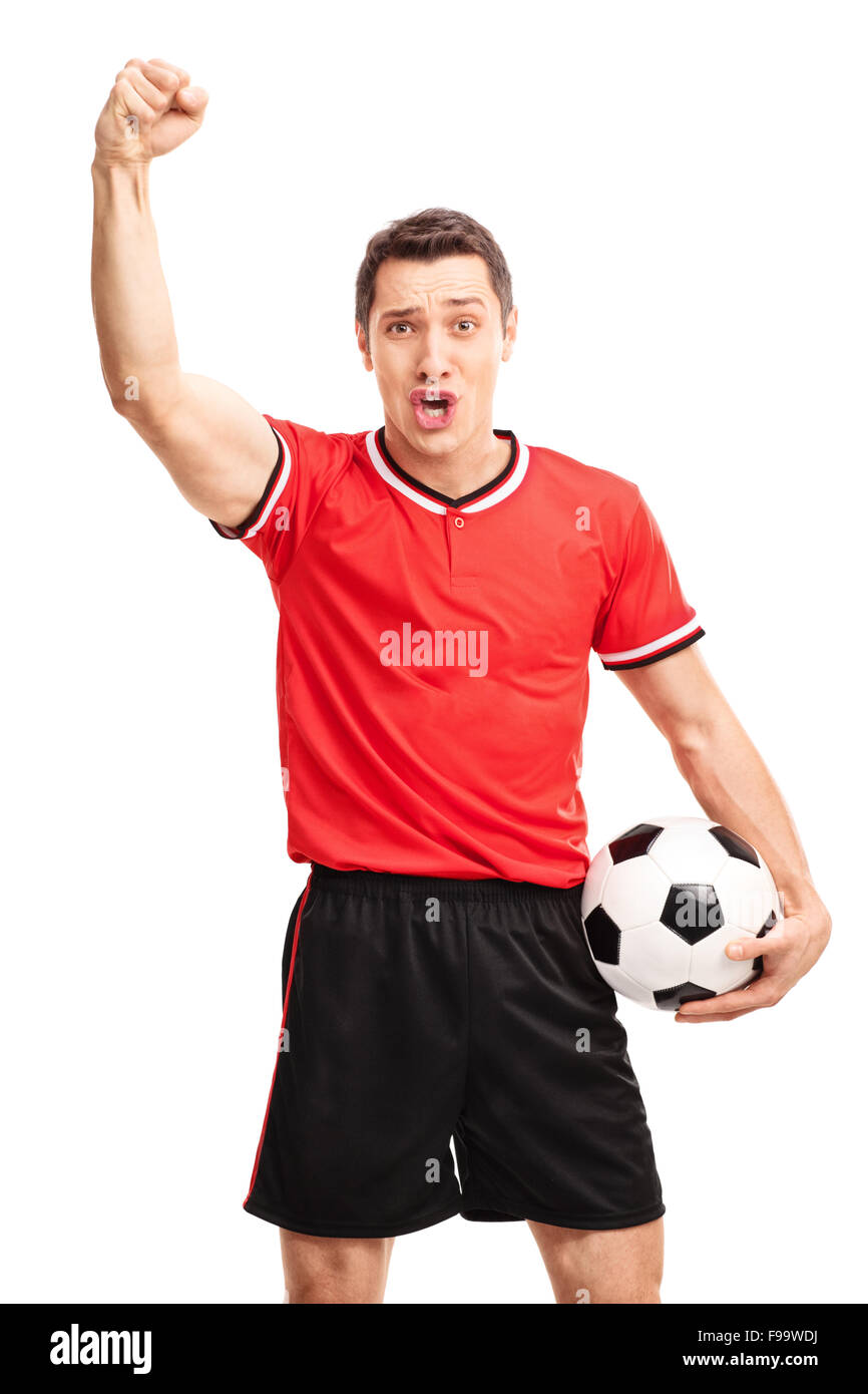 Vertical shot of a young football player holding a ball and gesturing success with his hand isolated on white background Stock Photo
