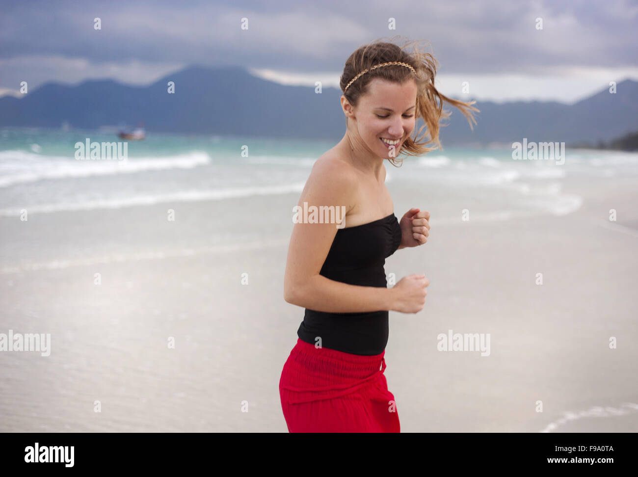 Beautiful young woman is enjoying free time at the beautiful sandy beach Stock Photo