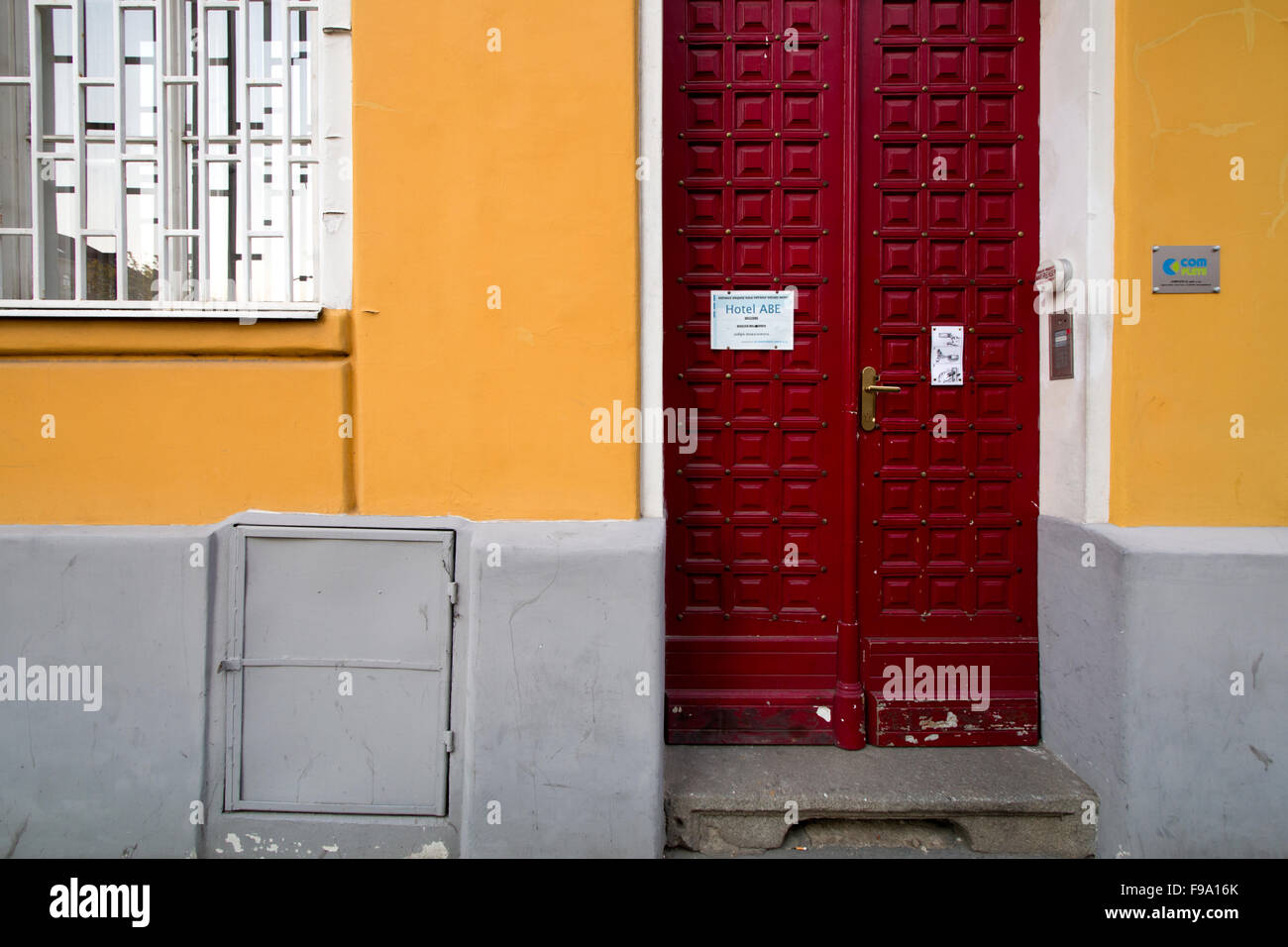 Bright red door on a yellow and grey wall Stock Photo